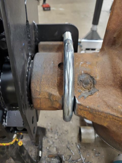 1996 Ford Bronco - A close-up view of a rusty metal component with a shiny metal loop, possibly part of a vehicle's suspension system.