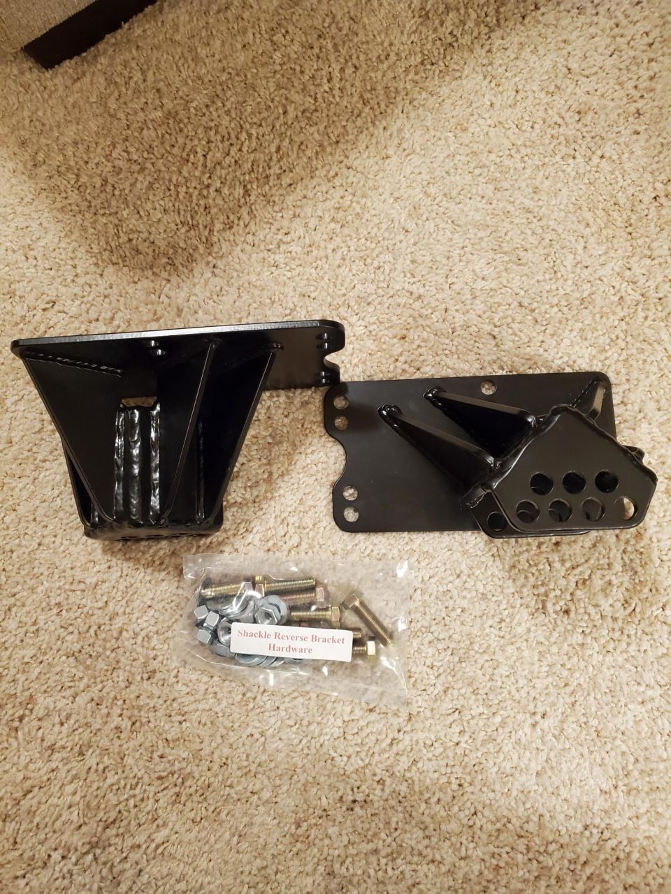 Shackle reverse bracket and hardware kit on carpet