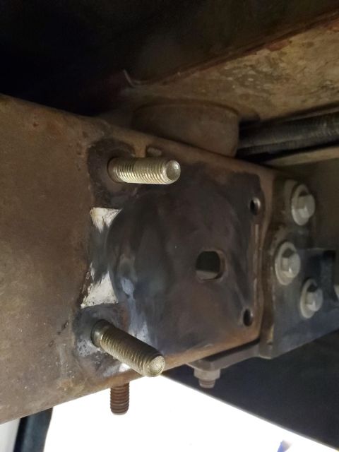 1996 Ford Bronco - Detail of vehicle undercarriage components, showing bolted metal brackets and rusty frame sections.