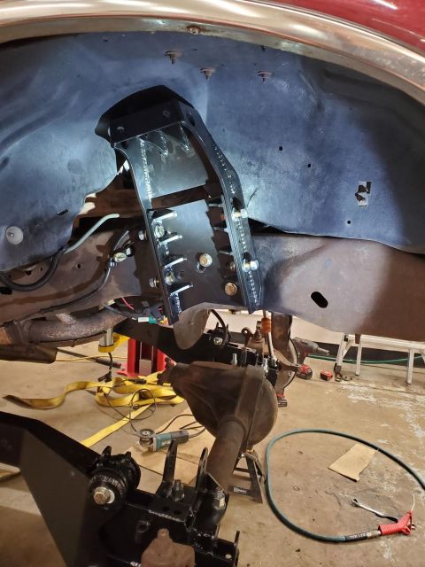 1996 Ford Bronco - Close-up view of a vehicle's suspension system undergoing modification, with a focus on the frame and newly installed components.