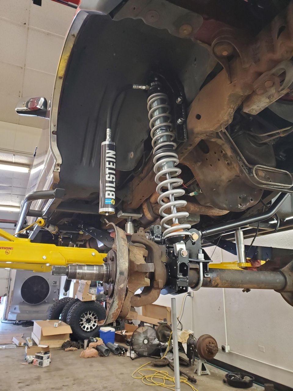 Suspension system with Bilstein shock absorber and coilover, lifted vehicle on yellow jack