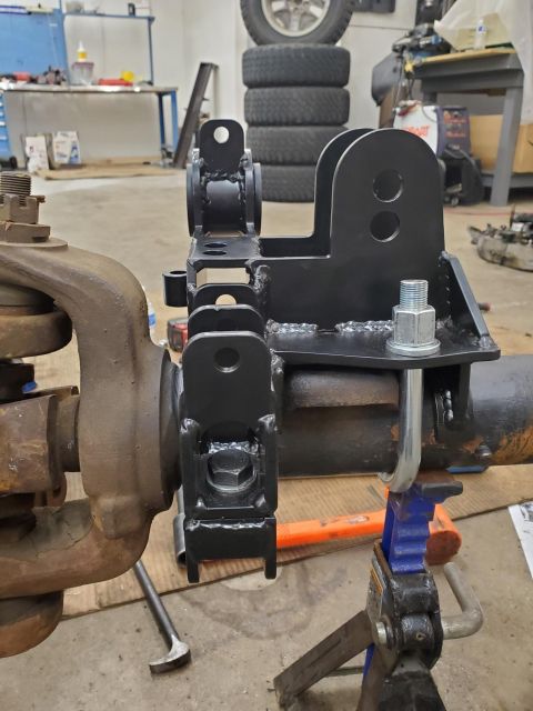 1996 Ford Bronco - Custom SAS swap suspension bracket installed on a vehicle axle in a workshop setting.