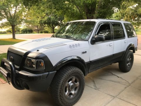 2000 Ford Explorer - White 2000 Ford Explorer SUV with black trim and off-road tires.