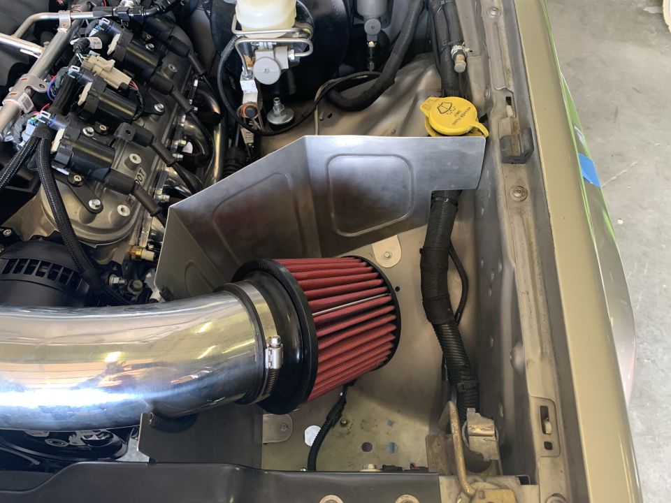 Engine bay with chrome intake tube and red air filter