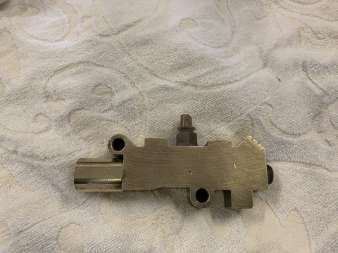 1979 Jeep CJ5 - A brass brake master cylinder, a crucial component for a vehicle's braking system, is shown against a textured background.