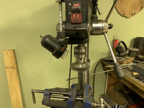 1979 Jeep CJ5 - A drill press is shown with a wire wheel attachment and a blue vise holding a piece of metal.