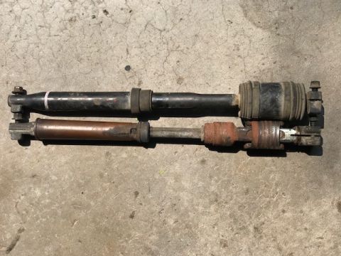 2000 Ford Explorer - Comparison of two steering shafts, one black and one rusty copper, on a concrete surface.