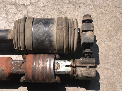 2000 Ford Explorer - Comparison of two shock absorbers, highlighting wear and tear on the rubber boot and rust on the metal components.