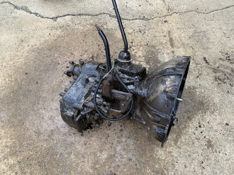 1979 Jeep CJ5 - Transmission and transfer case assembly from a Jeep, resting on a concrete surface.