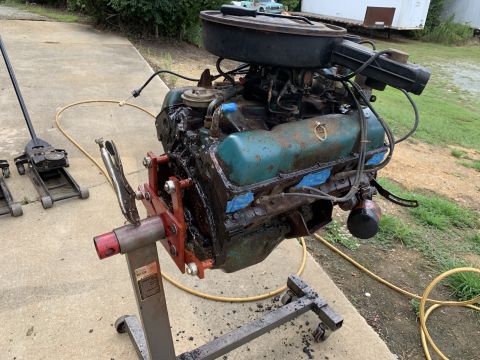1979 Jeep CJ5 - An engine is mounted on a stand, ready for work, with automotive tools visible in the background.