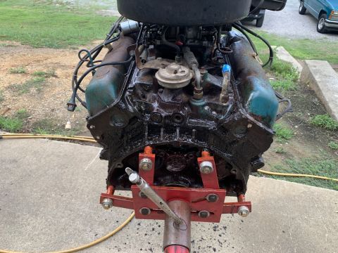 1979 Jeep CJ5 - This engine is mounted on a red stand and appears to be covered in oil, with visible blue valve covers.