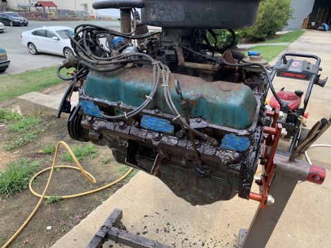 1979 Jeep CJ5 - Engine assembly with teal valve covers and a black oil pan, mounted on an engine stand.