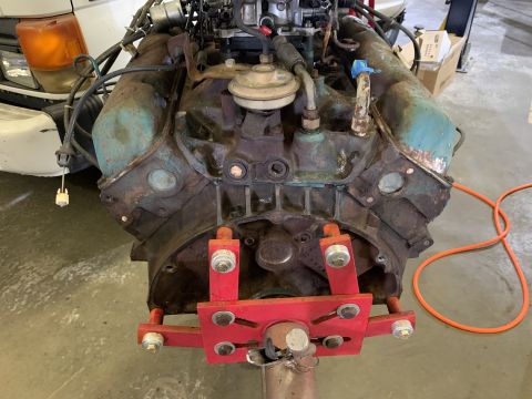1979 Jeep CJ5 - A V8 engine block, showing signs of rust and wear, is secured to a red engine stand.
