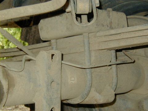 1994 Ford Explorer - Close-up view of the rear axle leaf spring assembly, showing U-bolts and a mounting bracket.