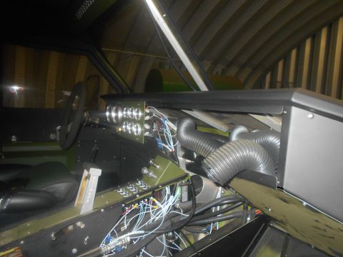 1992 Ford Bronco - The interior of a vehicle shows exposed wiring, multiple gauges, and flexible ducting, suggesting a custom or unfinished build.