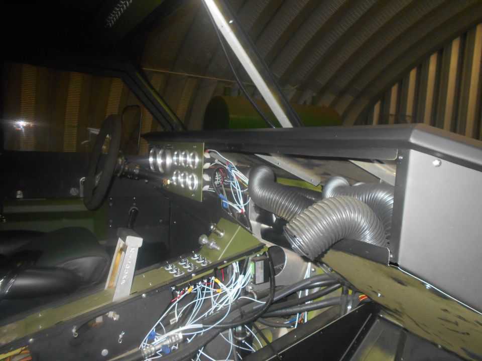 Vehicle interior with exposed wiring, gauges, and flexible ducting