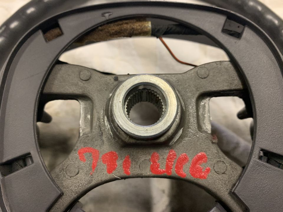Steering wheel hub with red markings '791 UGC' and a silver splined shaft