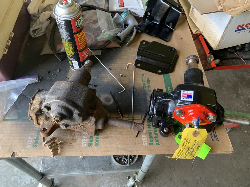 Two steering gearboxes, one rusty and one rebuilt with an American flag sticker