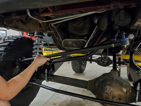 1996 Ford Bronco - Underside view of a vehicle's steering linkage, showing the tie rod and drag link assembly.