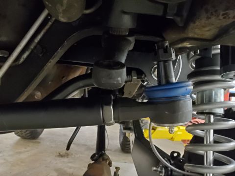 1996 Ford Bronco - Underside view of steering and suspension parts, including a tie rod end and coilover.