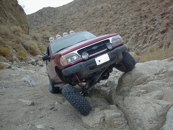 Red 2000 Ford Explorer navigating rocky terrain