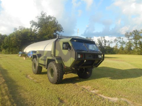 1992 Ford Bronco - This heavy-duty truck features a unique camouflage paint scheme and sits on a large grassy area.