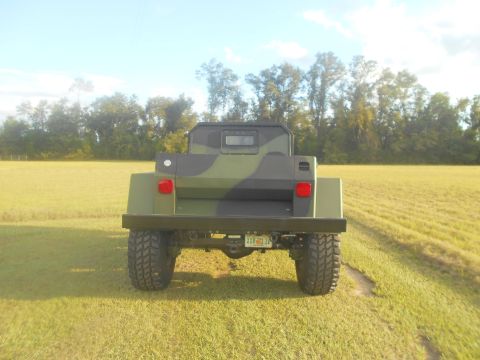 1992 Ford Bronco - This armored truck features a camouflage paint scheme and is viewed from the rear in an open field.