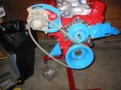 1985 Ford Bronco - Engine block assembly with alternator and pulleys, painted red and blue.