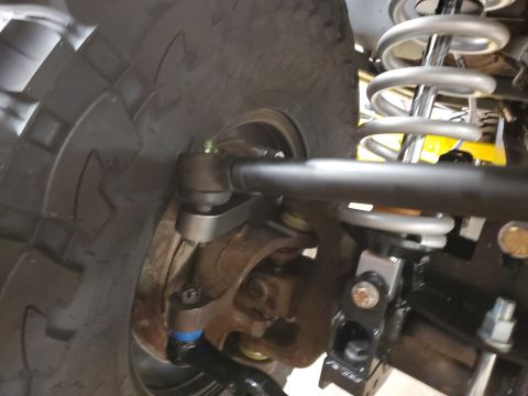 1996 Ford Bronco - Close-up view of the front suspension steering linkage and coilover shock assembly.