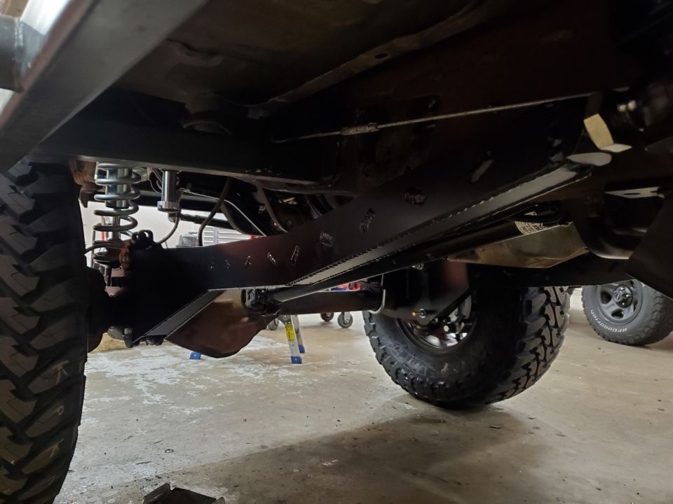Underside view of a vehicle with aftermarket suspension and off-road tires