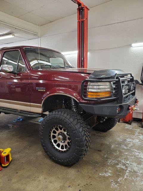 1996 Ford Bronco - This modified Ford Bronco is shown on a lift, aftermarket wheels and a heavy-duty front bumper.