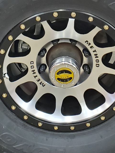 1996 Ford Bronco - Close-up of a Method wheel and Warn locking hub, indicating off-road modifications.