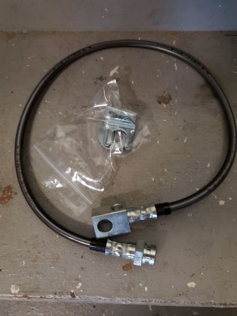 1996 Ford Bronco - New brake hose kit with fittings and mounting hardware laid out on a concrete floor.