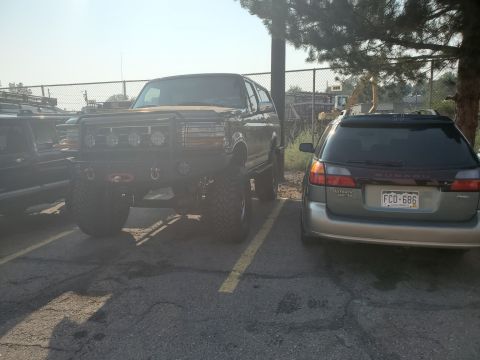 1996 Ford Bronco - Modified Ford Bronco with large tires and a heavy-duty front bumper is parked in a lot.
