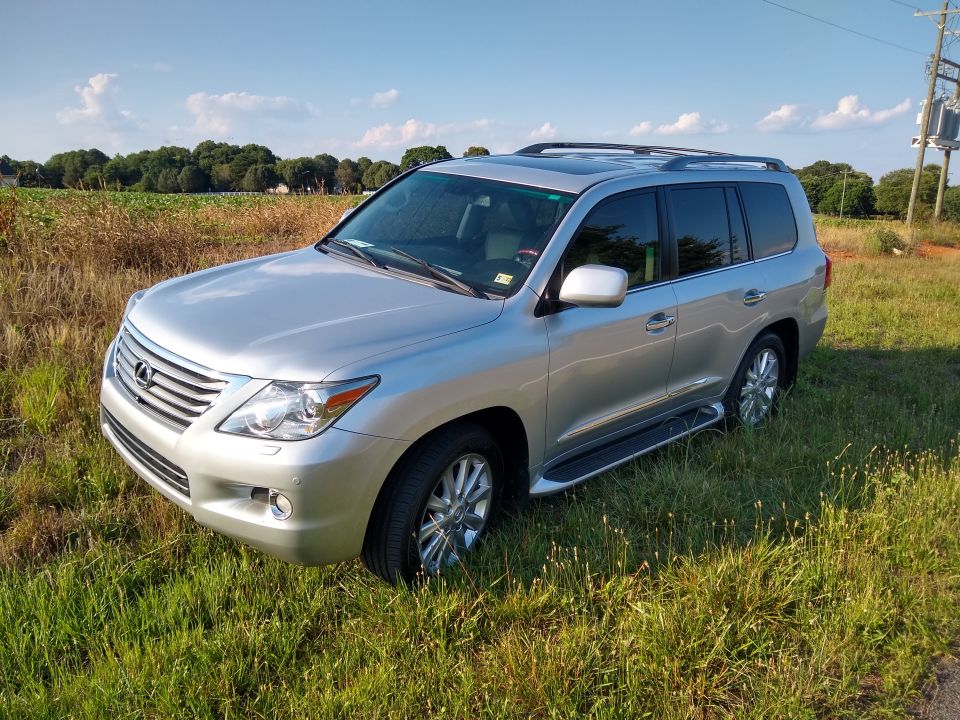 Silver Lexus LX 570 full-size SUV parked in a grassy field