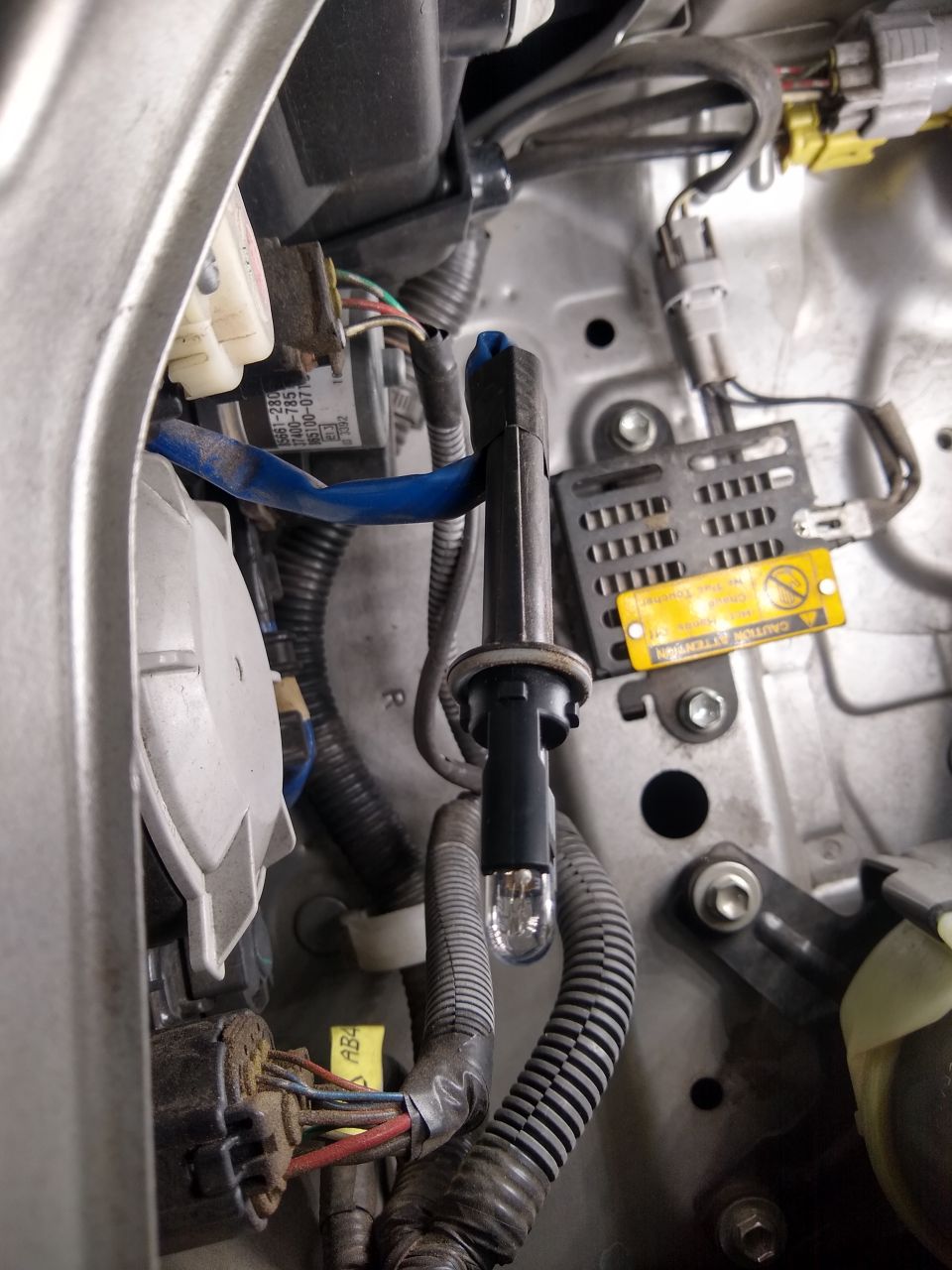 Engine bay detail with wiring harness, connectors and blue tape