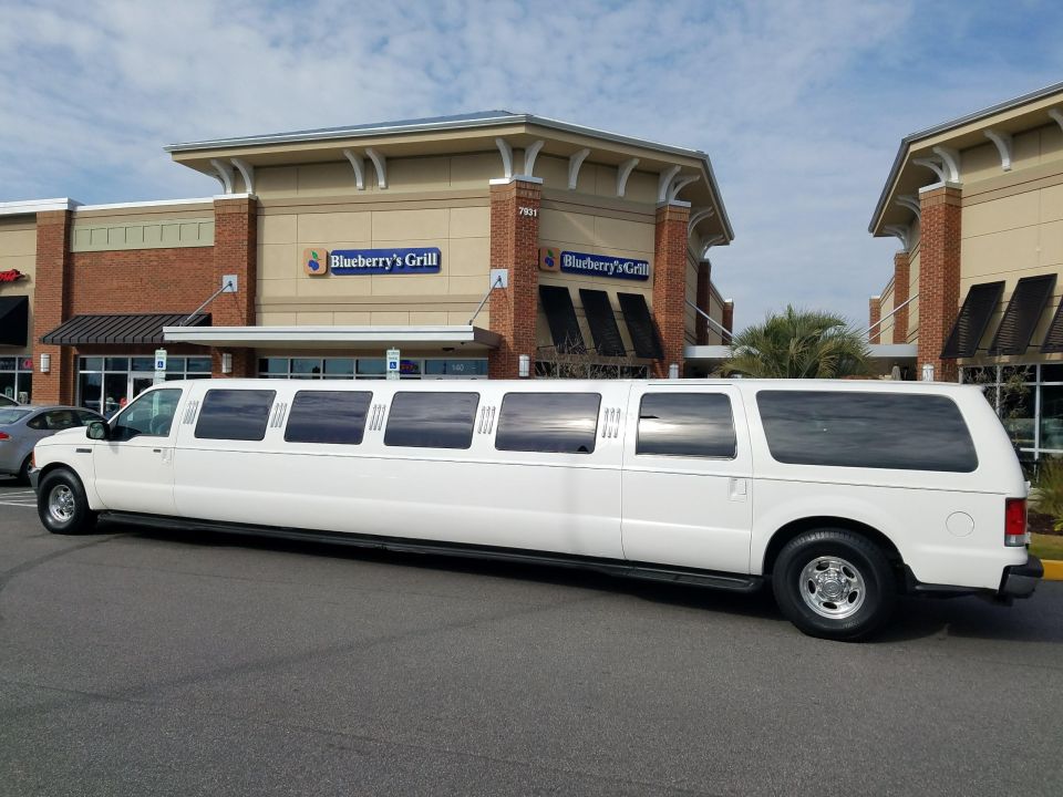White 2000 Ford Excursion limousine parked in front of a building with a Blueberry's Grill sign