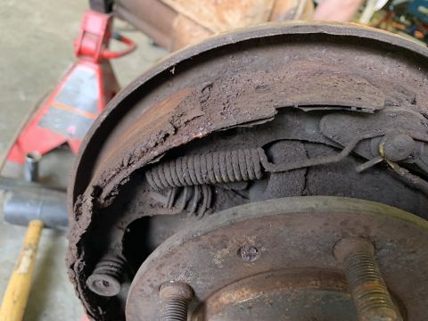 1979 Jeep CJ5 - Close-up of a corroded vehicle brake drum and shoe assembly, showing significant wear and damage.