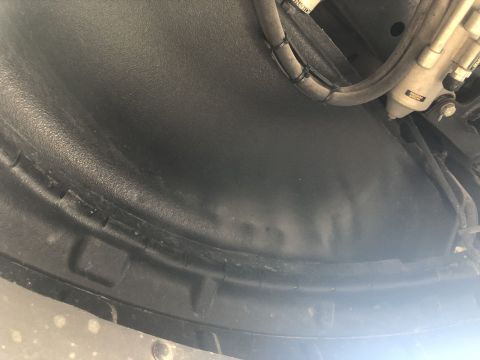 2014 Ford F-150 - Underside view of a vehicle's wheel well liner and suspension components.