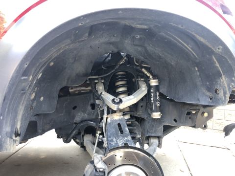 2014 Ford F-150 - Close-up view of the front suspension system, highlighting ICON brand shocks and control arms.