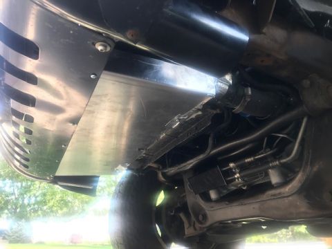 2000 Ford Explorer - Close-up of underbody skid plate and suspension components on a vehicle.