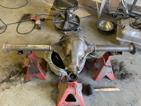 1979 Jeep CJ5 - Rear axle assembly supported by jack stands in a workshop setting, with tools present.