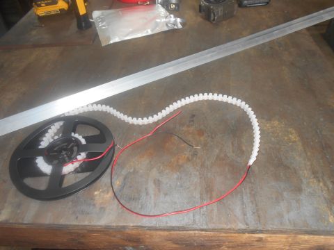 1992 Ford Bronco - A roll of LED strip lights and a metal ruler are laid out on a workbench surface.