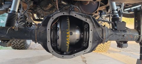 1996 Ford Bronco - A differential housing of a vehicle is open, revealing the gears inside. The housing is mounted on an axle with suspension components and t…