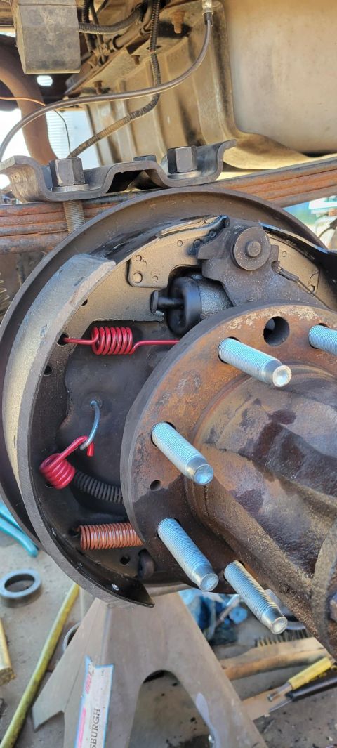 1996 Ford Bronco - A close-up view of the inside of a drum brake assembly on a vehicle, showing brake shoes, springs, and a wheel cylinder. The vehicle appear…
