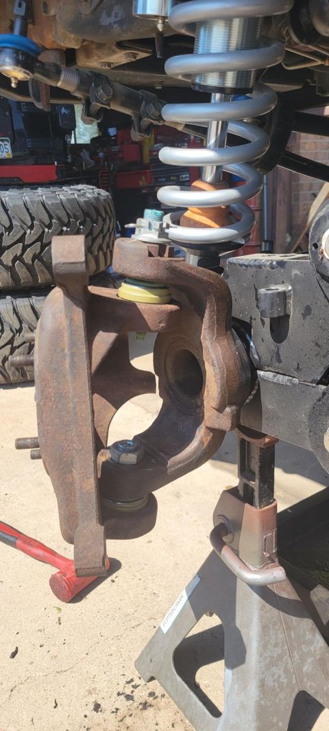 1996 Ford Bronco - Close-up view of vehicle suspension components, including a coilover shock and steering knuckle.