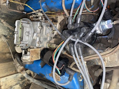 1976 Ford Bronco - Engine bay components including carburetor and distributor with spark plug wires.