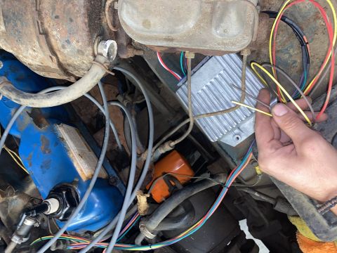 1976 Ford Bronco - Close-up of engine bay wiring and ignition module, with a hand holding a wire.