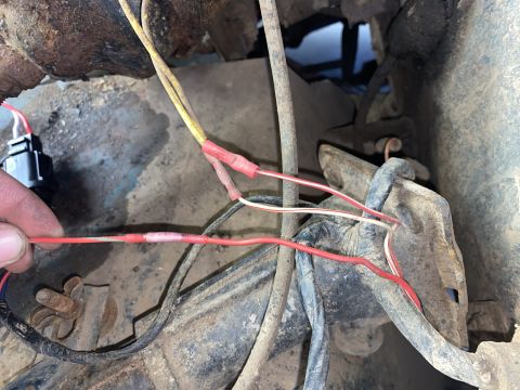 1976 Ford Bronco - A close-up view of a vehicle's electrical wiring, showing several wires connected with red crimp connectors.