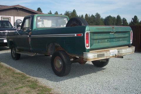 1977 Ford F-150 - This green 1977 Ford F-150 pickup truck is seen from the rear, with a spare tire mounted in the bed.